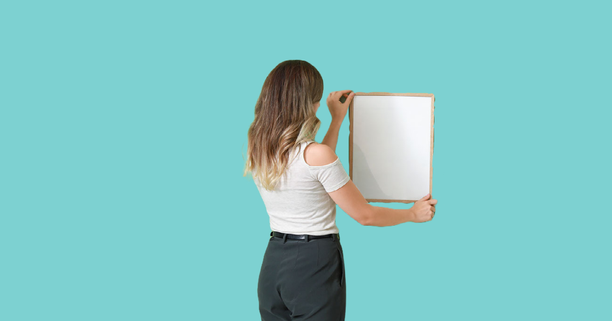 A woman hangs a picture