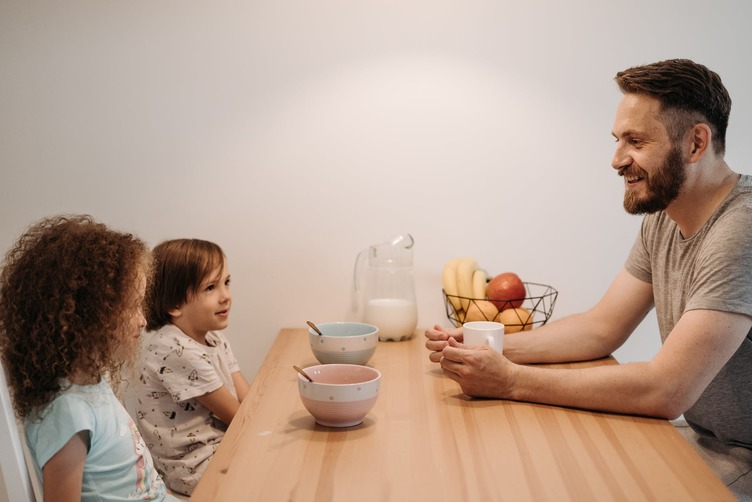 A man talks to his kids about their art.