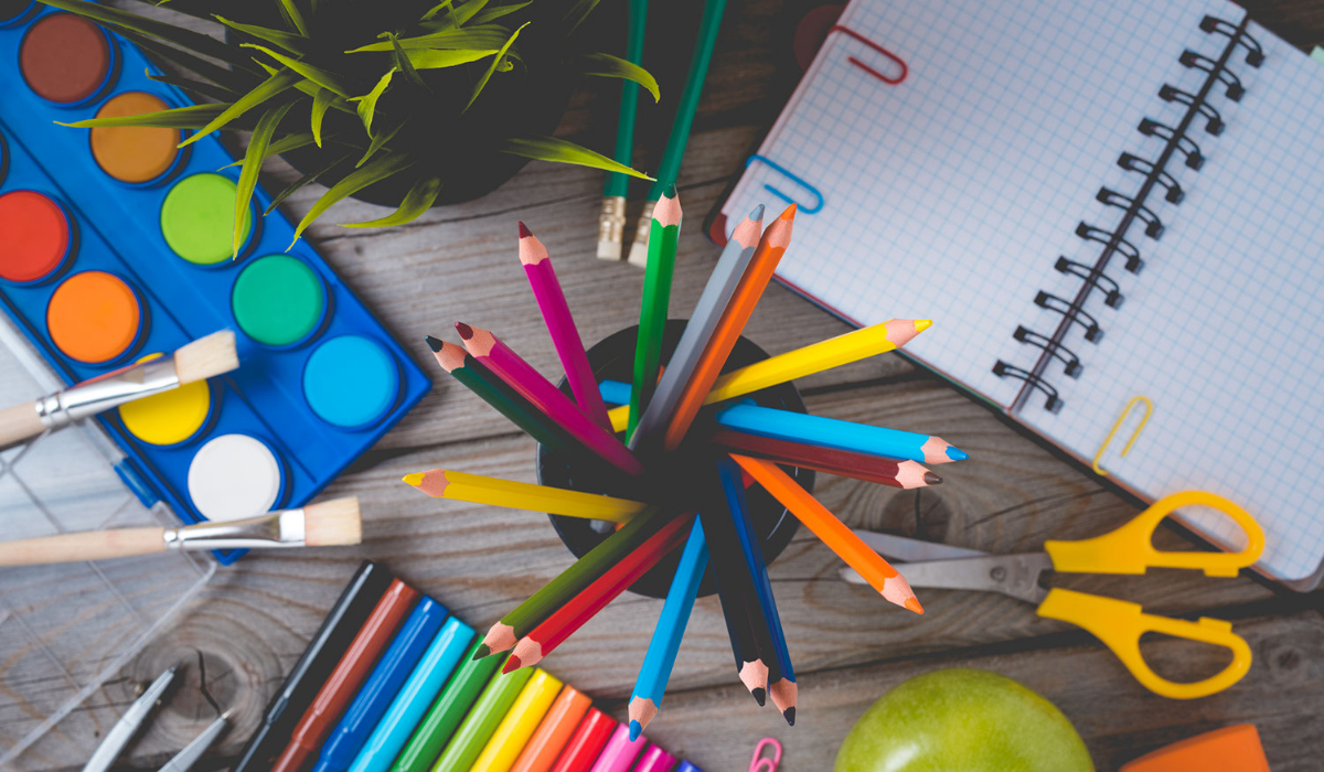 A set of tidy and clean art suplies sit on a desk.