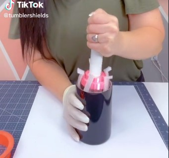 a woman inserts a tumbler holder into her tumbler